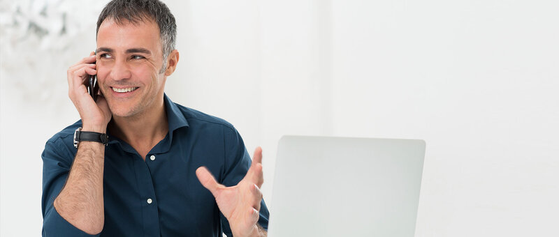 Mann mit Laptop und Smartphone