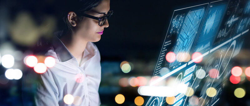 Frau vor Computerbildschirmen