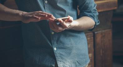 Hipster-Mann mit Smarphone lehnt an Möbel