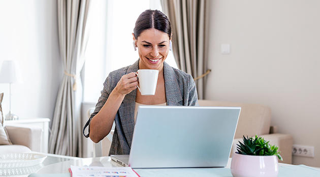 Frau macht eine virtuelle Kaffeepause vor dem Laptop