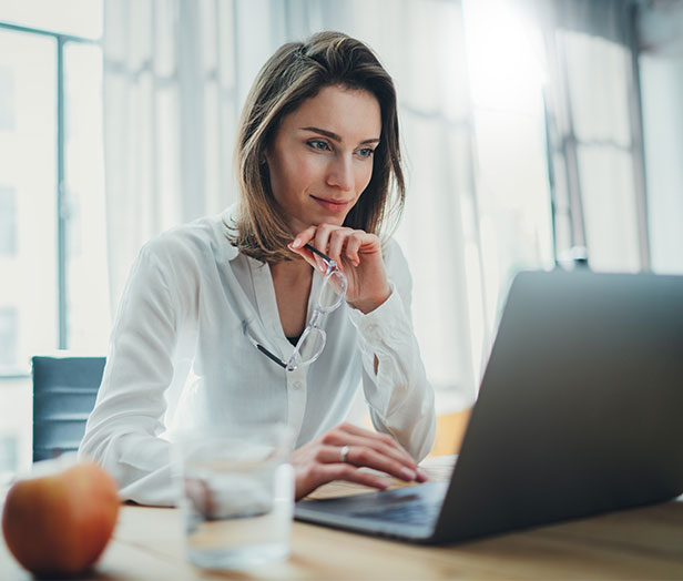 Frau im Büro surft am Laptop